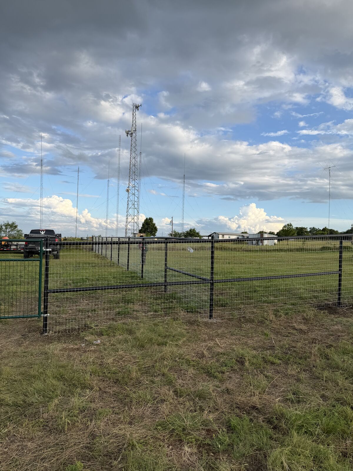 Wire pasture fencing with pipe posts under a big Texas sky